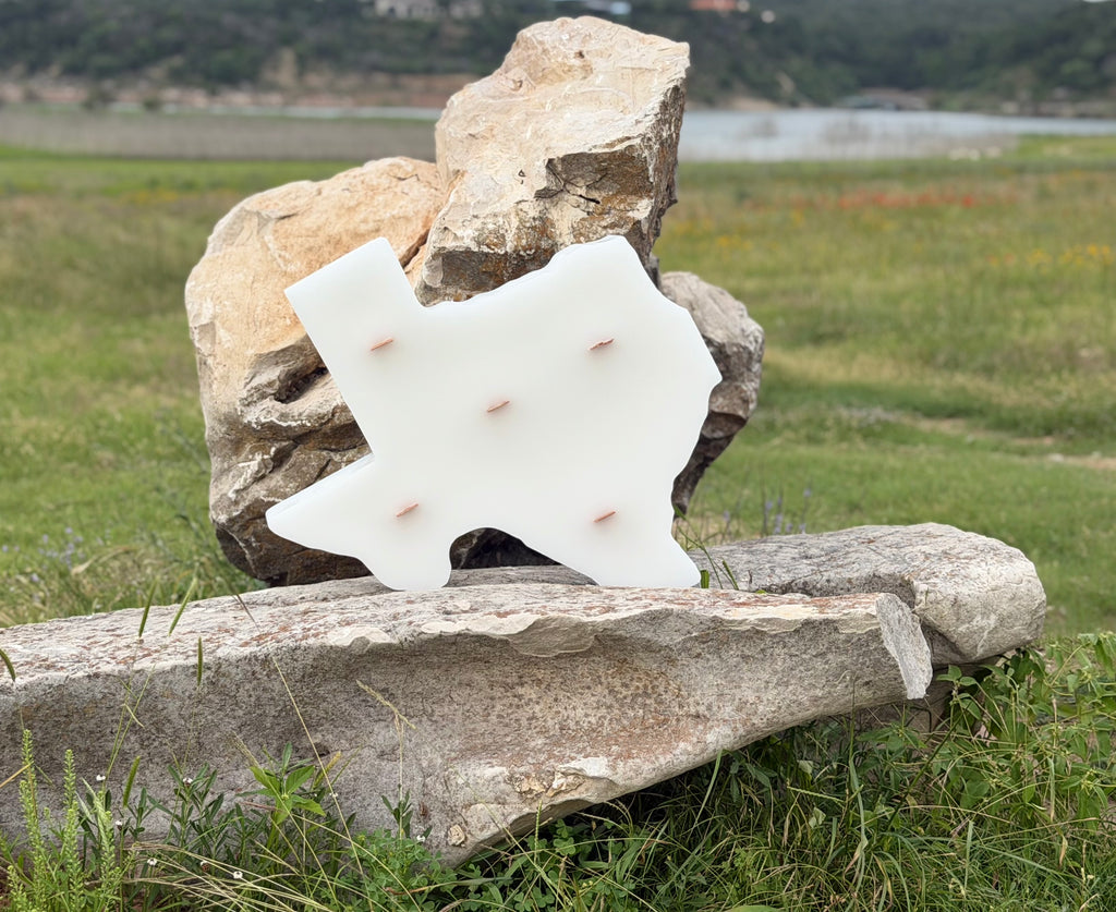 Handcrafted Texas silhouette paraffin pilar candle with five wood wicks displayed outdoor on natural store
